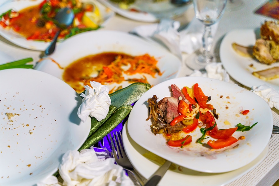 Half eaten dishes left at a restaurant table create the Repercussions of Food Waste